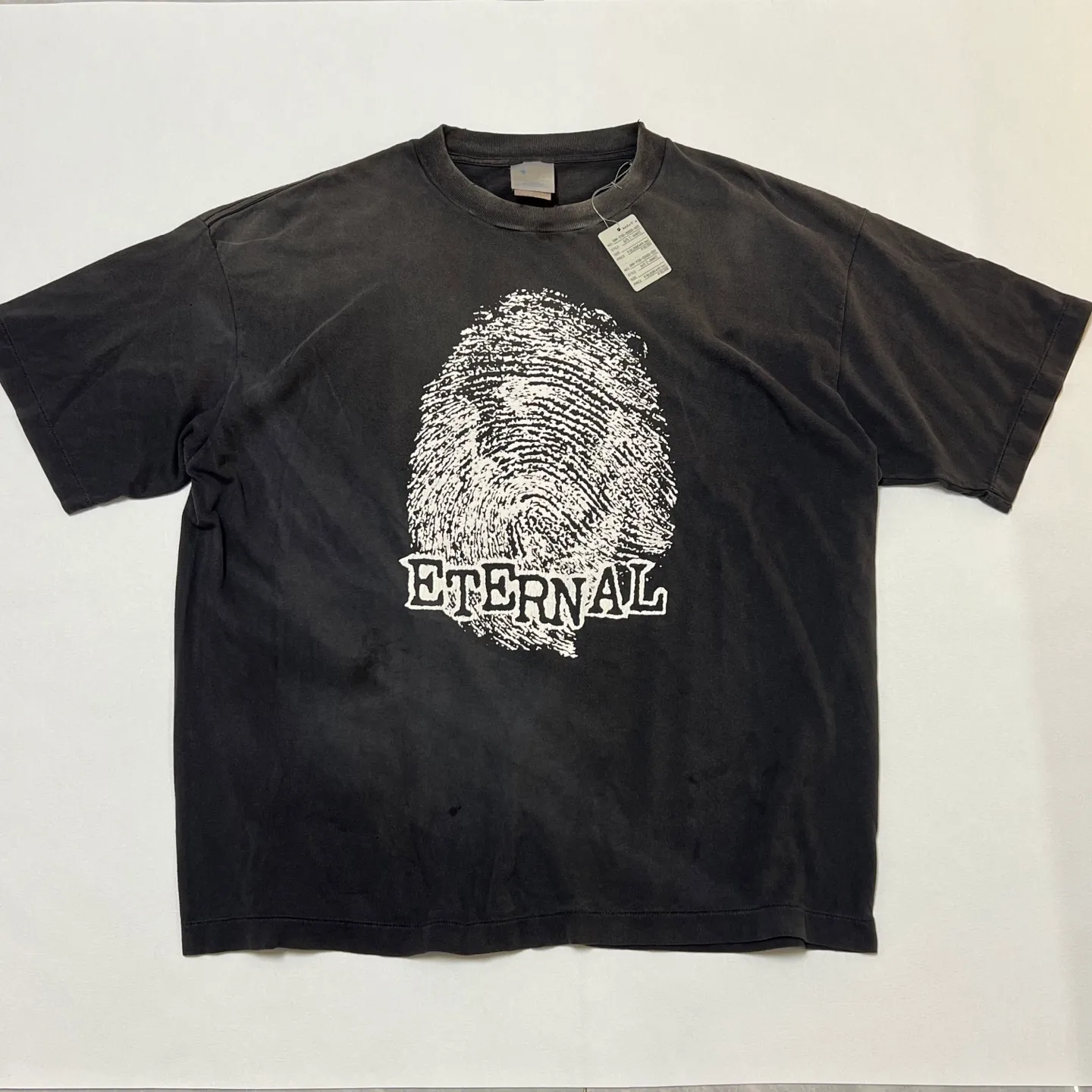 SAINT Mxxxxxx CHOSEN SS TEE/BLK Burst pattern/fingerprint print Chosen Tee Washed black S-XL Look for cylindrical fabrics without side seams. Don’t buy open-width fabrics anymore. It’s boring. Assute garment dyeing. Spray the whole piece with Ma Liu. Re-spray heavy fade. Collar and cuffs are frayed. Many places are broken. Authentic grade printing restored. Original consistent main mark/wash mark/with little angel anti-counterfeiting label.